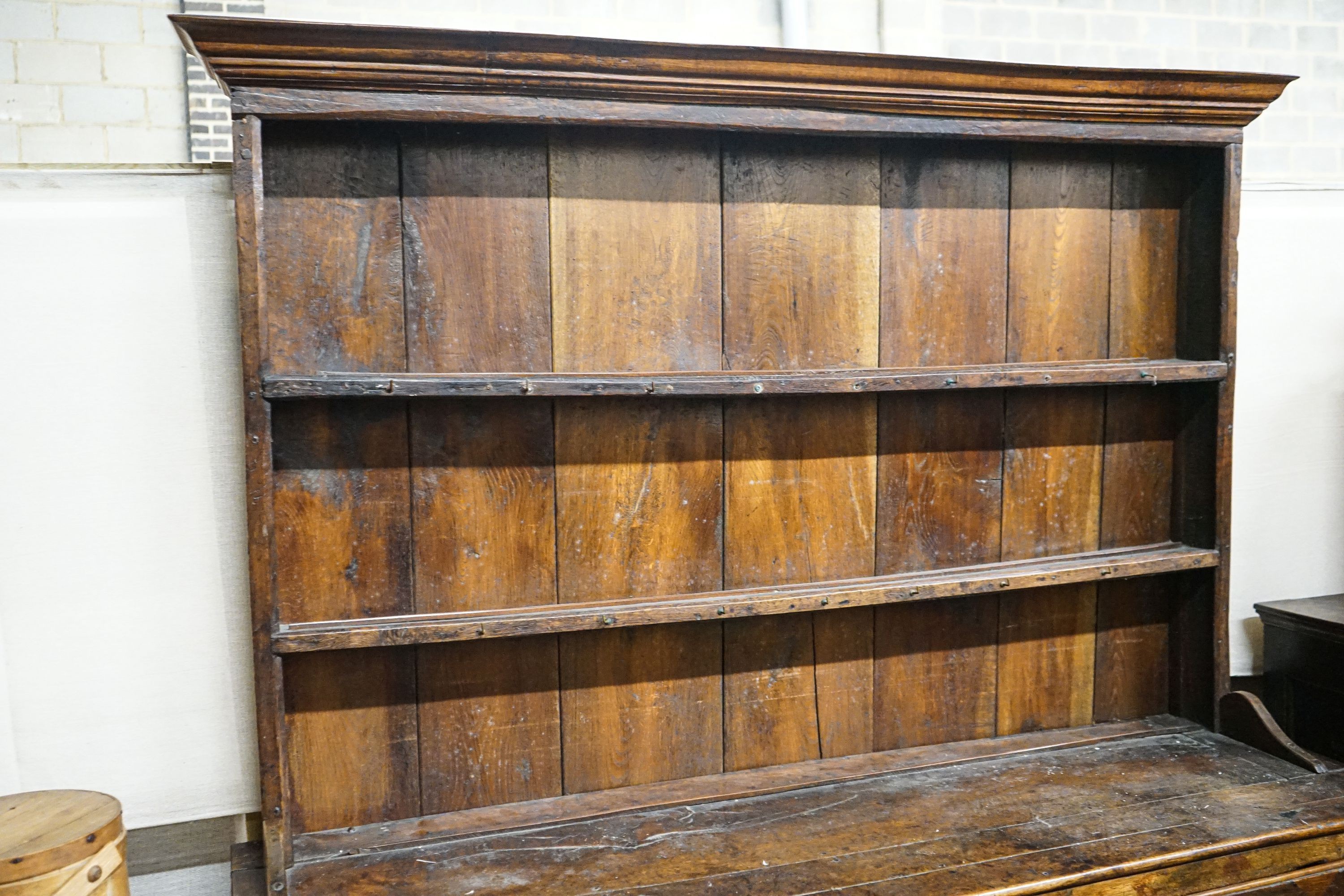 A George III oak dresser, with two shelf rack and three long drawers, on chamfered legs, width 167cm, depth 49cm, height 193cm